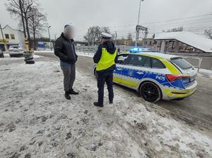 Na zdjęciu policjant rozdający odblaski