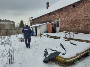 Na zdjęciu policjant idący do pustostanu