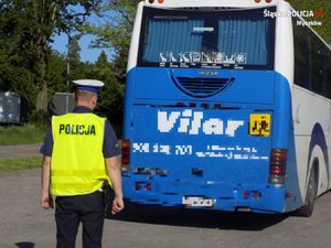 Na zdjęciu policjant stojący przy autokarze