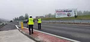Na zdjęciu policjanci ruchu drogowego mierzący prędkość