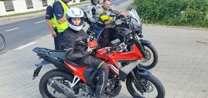 Na zdjęciu policjanci, którzy rozdają motocyklista odblaski i apteczki