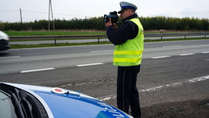 Na zdjęciu policjant ruchu drogowego mierzący prędkość