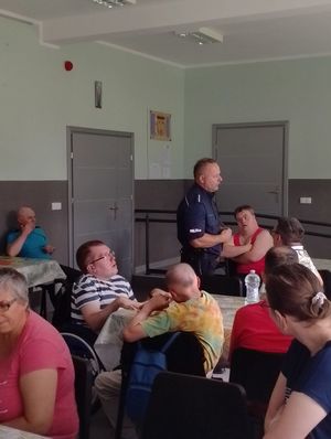 Na zdjęciu policjant z osobami niepełnosprawnymi