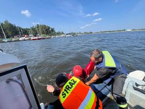 Na zdjęciu pozorant, który jest wyciągany z wody przez strażaków