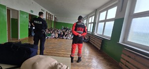 Na zdjęciu uczniowie, policjant i ratownik medyczny