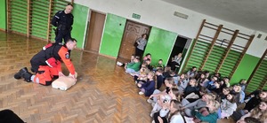 Na zdjęciu uczniowie, policjant i ratownik medyczny