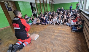Na zdjęciu uczniowie, policjant i ratownik medyczny