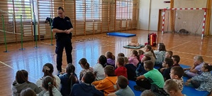 Na zdjęciu znajduje się umundurowany policjant wraz z przedszkolakmi