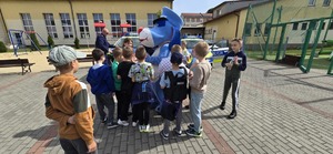 Na zdjęciu umundurowani policjanci, sznupek i dzieci