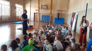 Zdjęcie przedstawia policjanta, dzieci oraz Panie nauczycielki