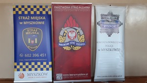 Na zdjęciu logo Komendy Powiatowej Policji w Myszkowie, Straży Miejskiej i Państwowej Straży Pożarnej w Myszkowie