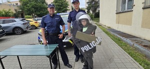 Na zdjęciu w policyjnym stroju obok umundurowanych policjantów