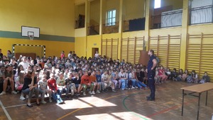 Na zdjęciu policjant rozmawiający z uczniami