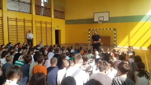 Na zdjęciu policjant rozmawiający z uczniami