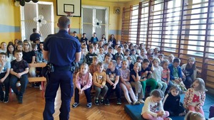 Na zdjęciu policjant rozmawiający z uczniami
