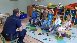 Na zdjęciu policjant rozmawiający z uczniami