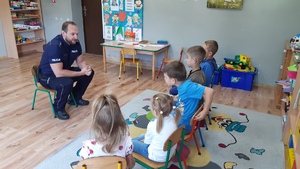 Na zdjęciu policjant rozmawiający z uczniami
