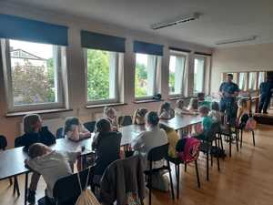 Zdjęcie na którym znajduje się dzielnicowy oraz uczniowie