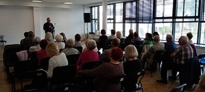 Zdjęcie policjanta z uczestnikami prelekcji