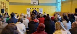 Na zdjęciu przemawiający do rodziców policyjny profilaktyk