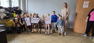 Na zdjęciu grupa dzieci, dwoje z nich trzyma plakat z napisem &quot;Dzieciństwo bez przemocy&#039;&#039;