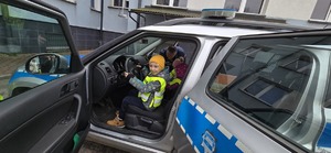 Na zdjęciu chłopiec siedzący w policyjnym radiowozie