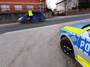 Na zdjęciu widać policjanta ruchu drogowego przeprowadzającego badanie trzeźwości