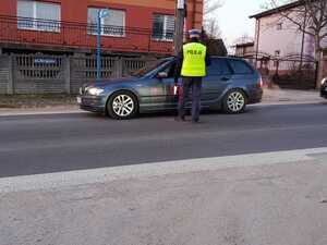 Na zdjęciu widać policjanta ruchu drogowego przeprowadzającego badanie trzeźwości