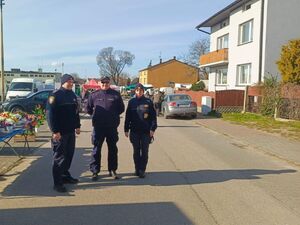 Na zdjęciu widać strażników miejskich oraz dzielnicowego, którzy znajdują się na targowisku miejskim