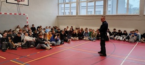 Na zdjęciu profilaktyk policyjny i młodzież