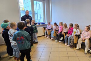 Na zdjęciu widać przedszkolaki oraz umundurowanych policjantów